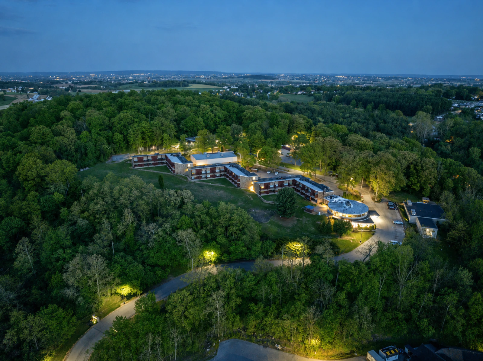 Aerial view of the Keystone Retreat Behavioral Health Center surrounded by greenery, showing the full facility and parking lot.